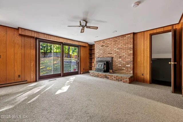 a view of an empty room with a fireplace and a window