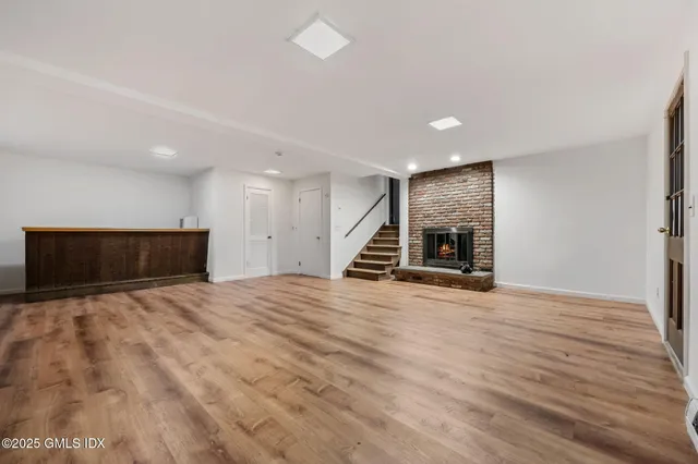a view of empty room with wooden floor and fireplace