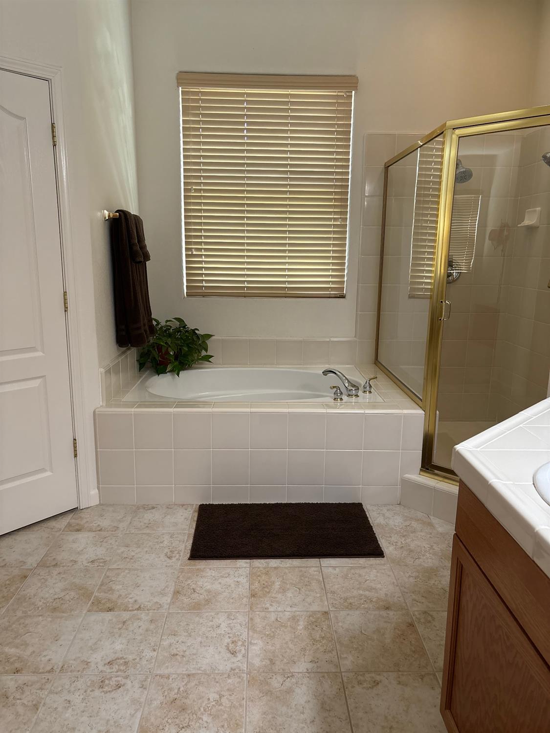 2644 Gibson Avenue Clovis, CA 93611 - Photo 11 of 21 a bathroom with a tub a sink and a shower