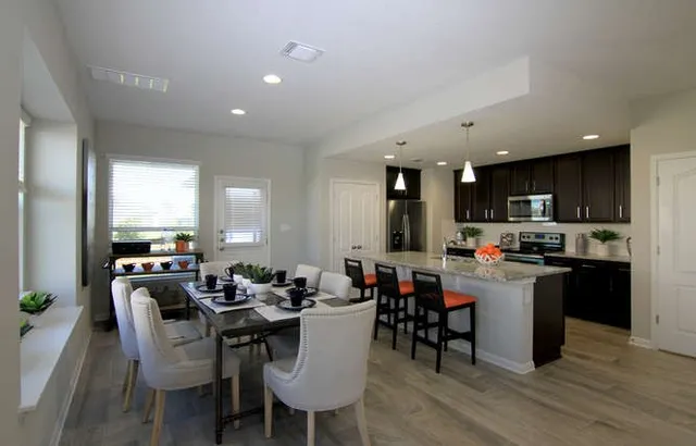 a kitchen with a dining table chairs and a counter top space