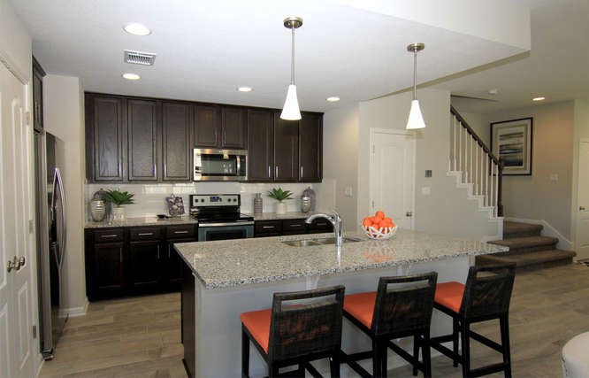 708 Tinton Falls Lane Pflugerville, TX 78660 - Photo 12 of 40 a kitchen with stainless steel appliances granite countertop a stove top oven a refrigerator a sink and chairs