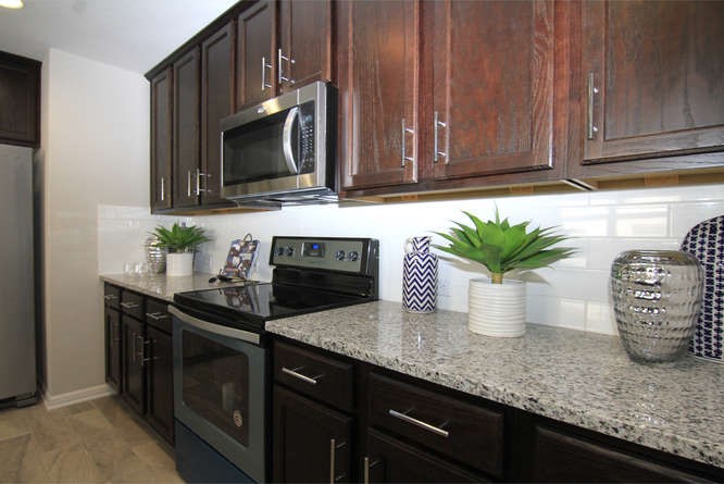 708 Tinton Falls Lane Pflugerville, TX 78660 - Photo 19 of 40 a kitchen with granite countertop a sink stainless steel appliances and cabinets
