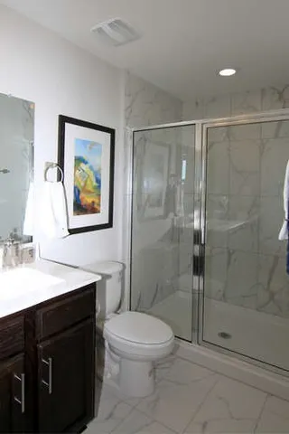 a bathroom with a sink a toilet and shower