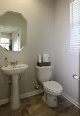 a bathroom with a sink toilet and mirror
