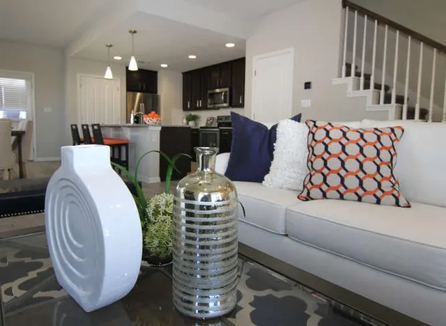 a living room with furniture a chandelier and kitchen view