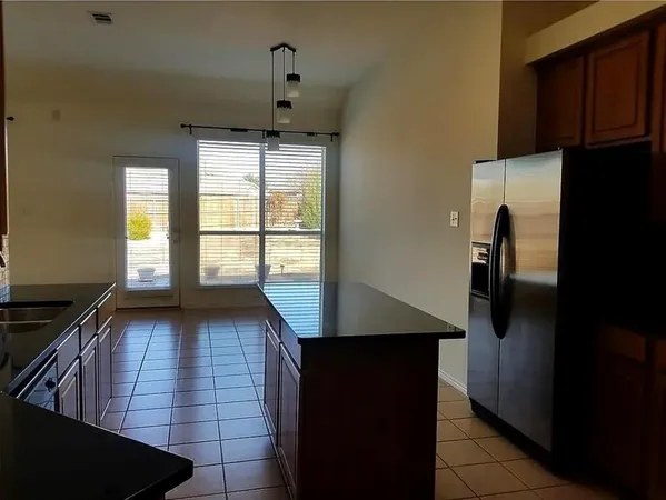 a view of a kitchen with an empty space and a window