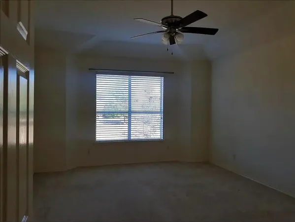 a view of a livingroom with a ceiling fan and window