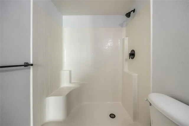 a view of a livingroom with a ceiling fan wooden floor and a ceiling fan