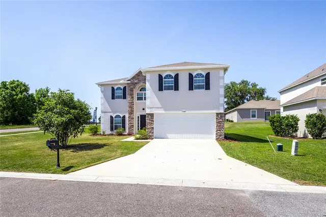 an empty room with wooden floor chandelier fan and windows