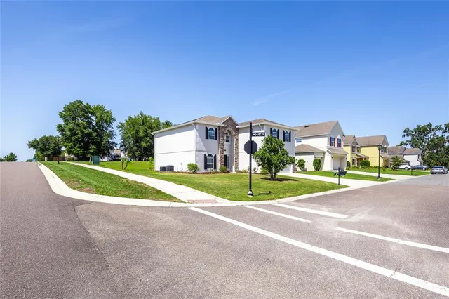 an empty room with wooden floor chandelier fan and windows