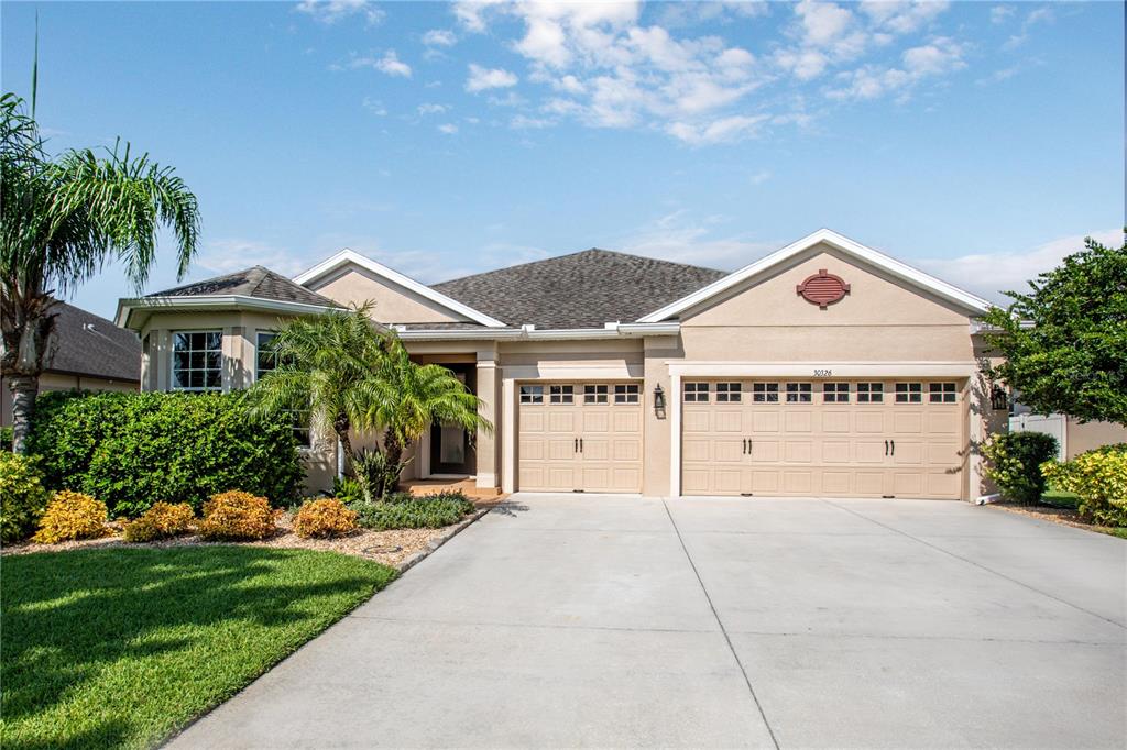 30326 Hackney Loop Mount Dora, FL 32757 - Photo 1 of 1 a front view of a house with a garden and trees