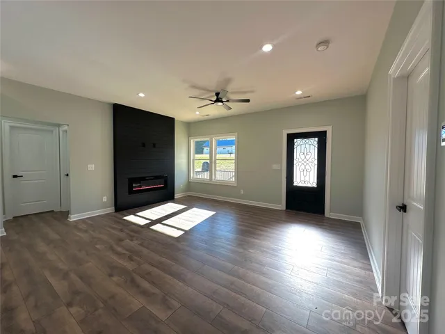 a view of empty room with window and wooden floor