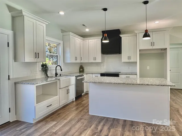 a kitchen with stainless steel appliances granite countertop a sink a stove and a refrigerator