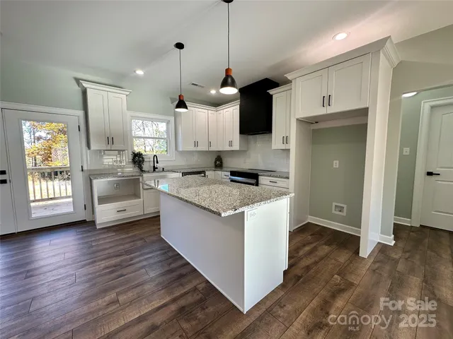 a kitchen with granite countertop a sink and a stove top oven