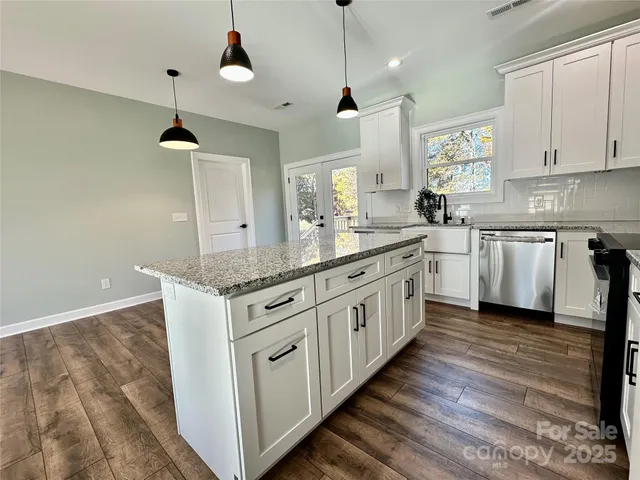 a kitchen with granite countertop white cabinets and white appliances
