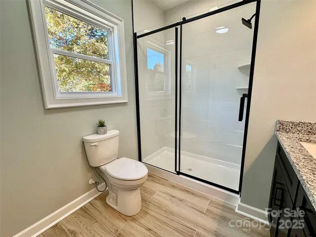 a bathroom with a toilet and a shower