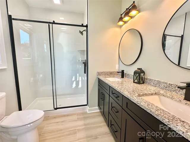 a bathroom with a granite countertop sink toilet and a mirror