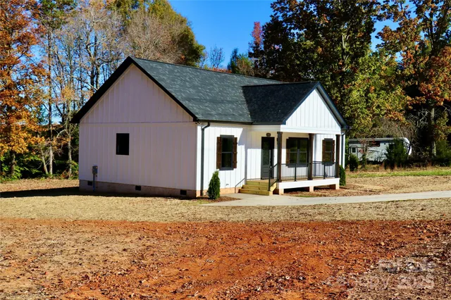 a front view of house with yard and trees in the background