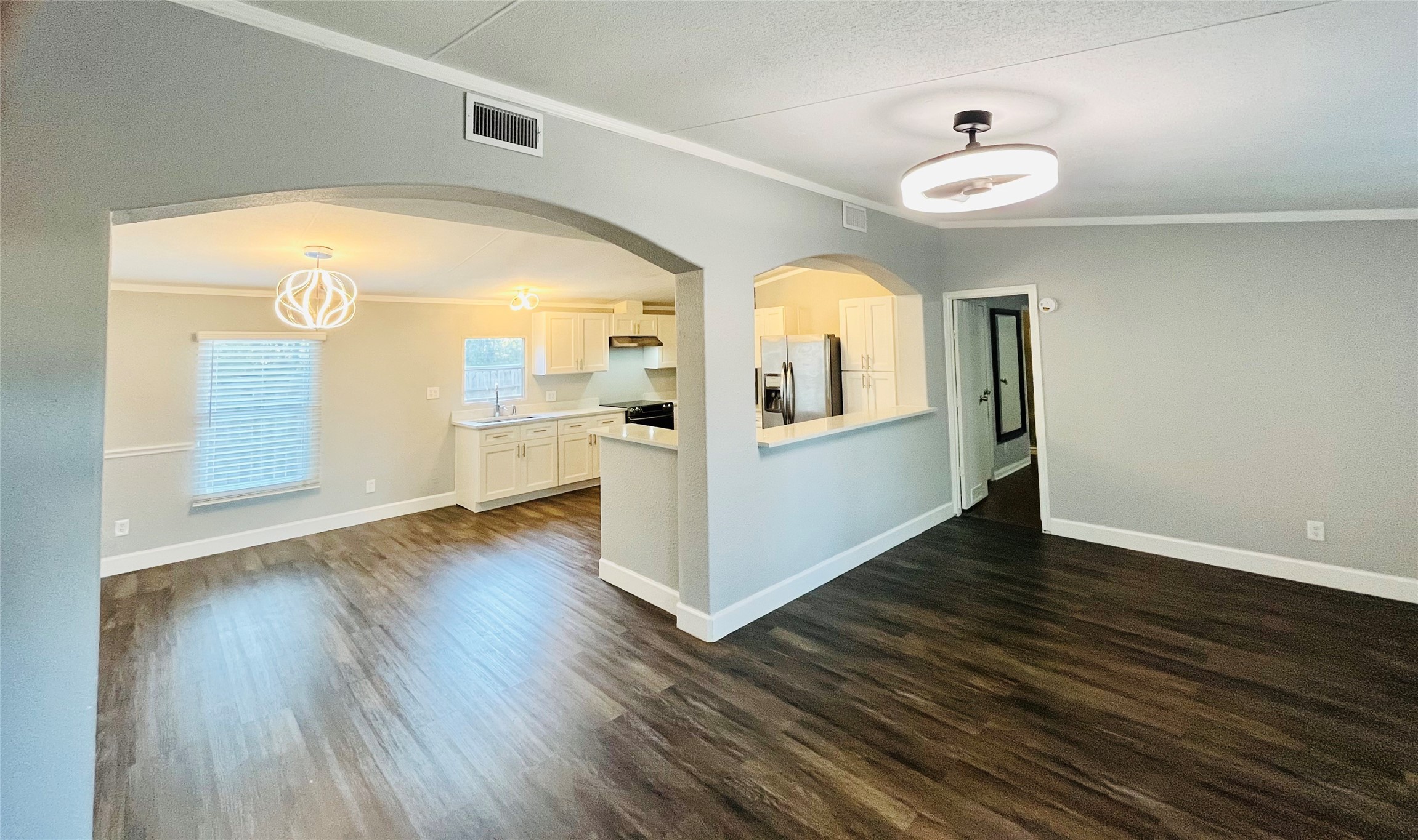 a view of a living room and bathroom with wooden floor