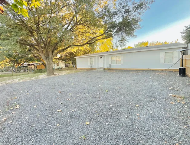 a view of house with backyard and trees