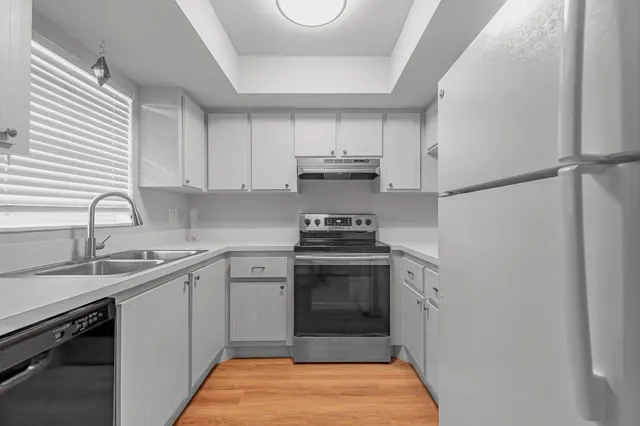 a kitchen with a sink stove and cabinets