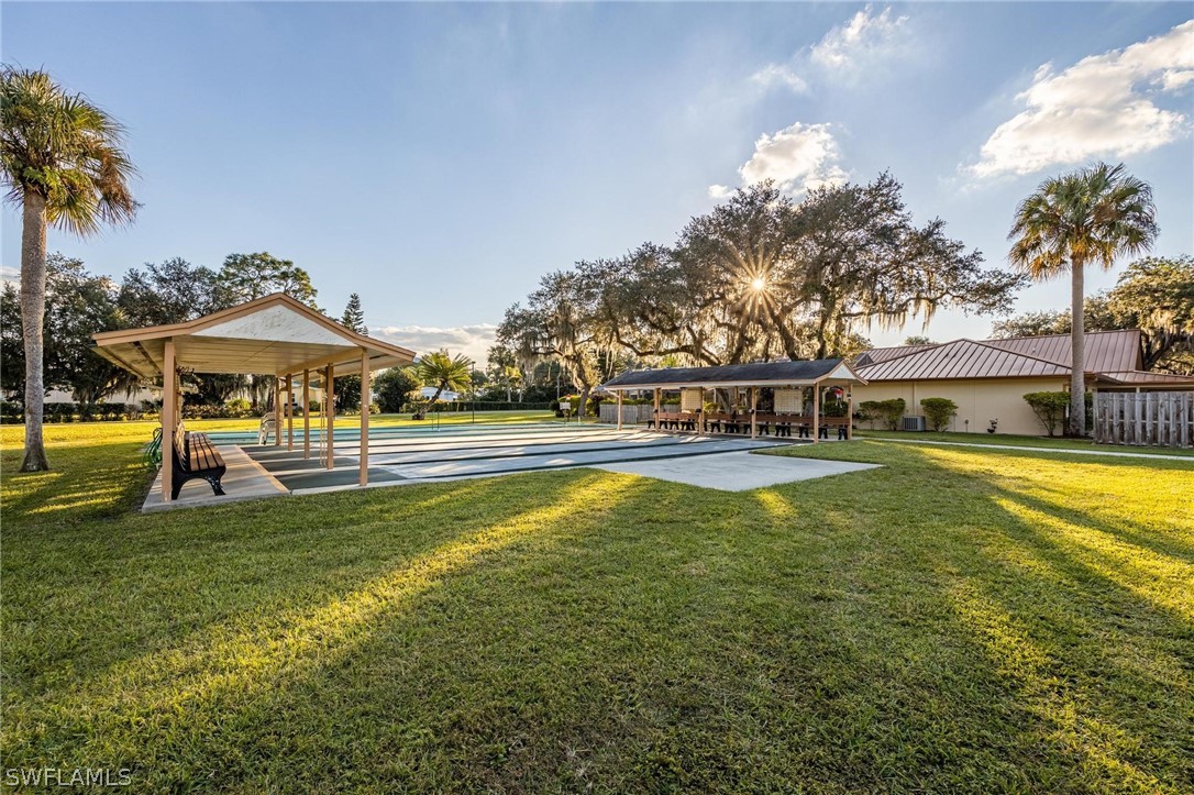 27 Aloe Alva, FL 33920 - Photo 31 of 33 a view of a swimming pool with lawn chairs under an umbrella