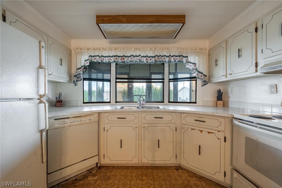 27 Aloe Alva, FL 33920 - Photo 6 of 33 a kitchen with white cabinets and white appliances