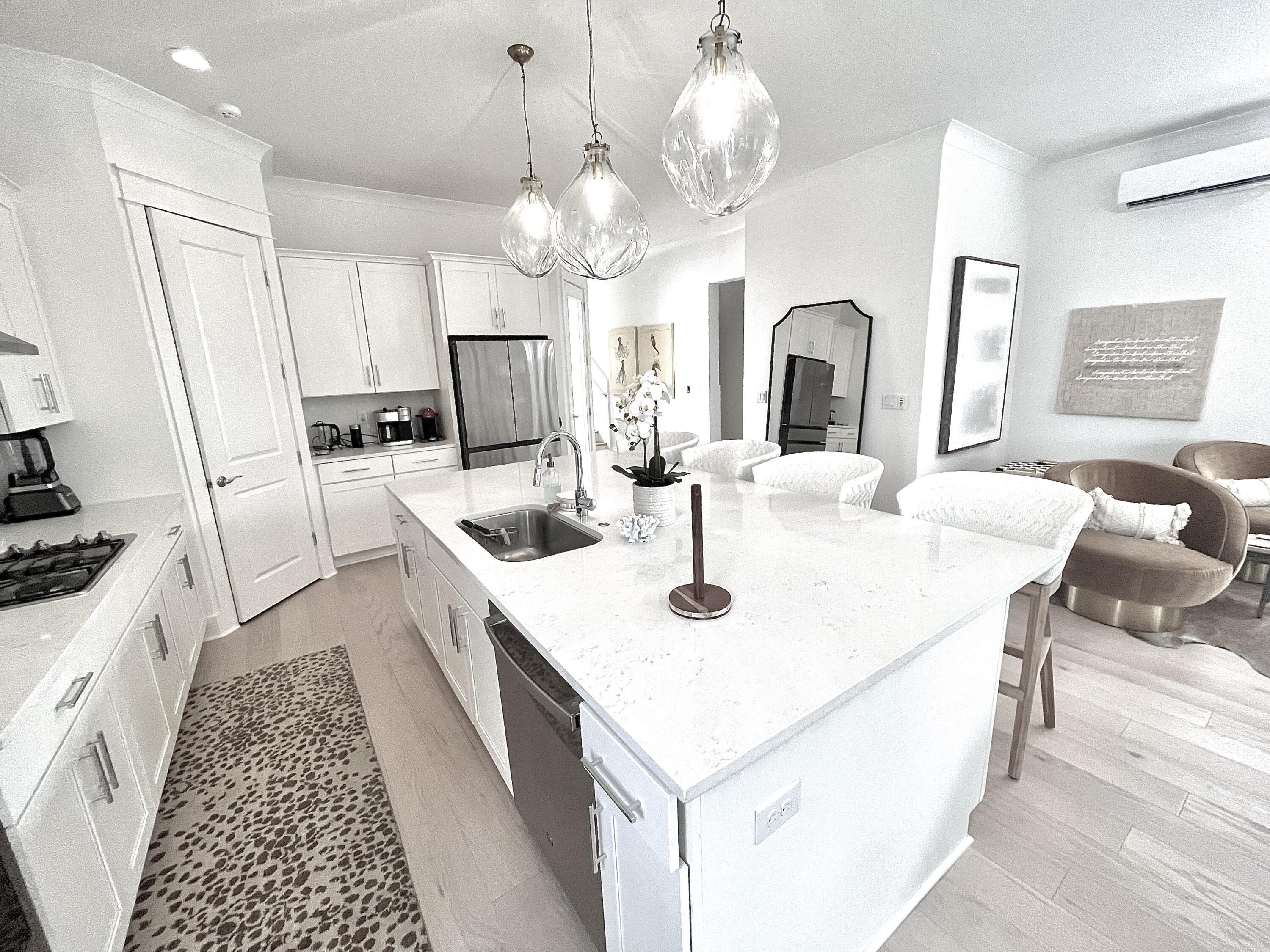 141 Valdare Ln Inlet Beach Inlet Beach, FL 32461 - Photo 16 of 55 a large kitchen with kitchen island a stove a sink a dining table and chairs with wooden floor