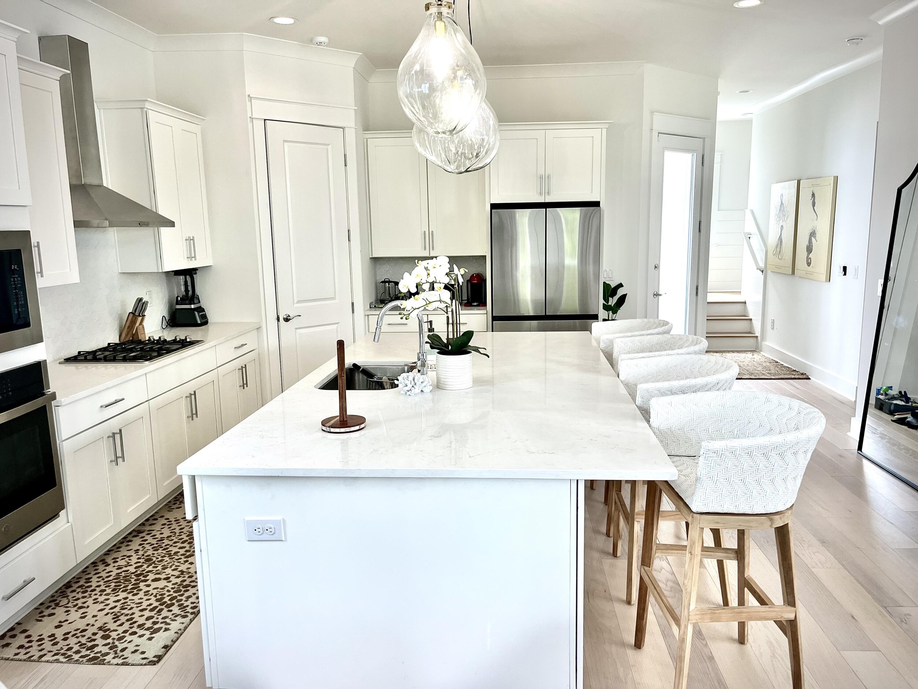 141 Valdare Ln Inlet Beach Inlet Beach, FL 32461 - Photo 18 of 55 a kitchen with granite countertop a sink a stove top oven a dining table and chairs