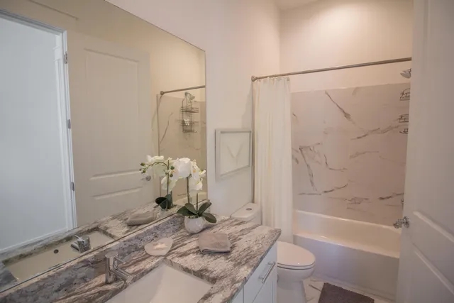a bathroom with a granite countertop sink toilet and shower