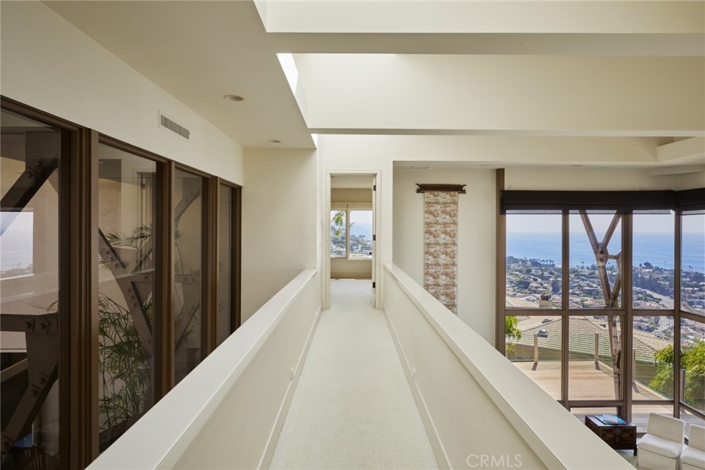 1513 Emerald Bay Laguna Beach, CA 92651 - Photo 29 of 44 a view of a hallway with wooden floor and windows