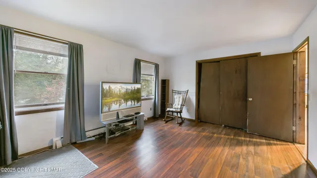 a view of a room with wooden floor and windows