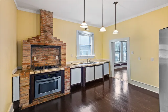 a large kitchen with a stove and a wooden floor