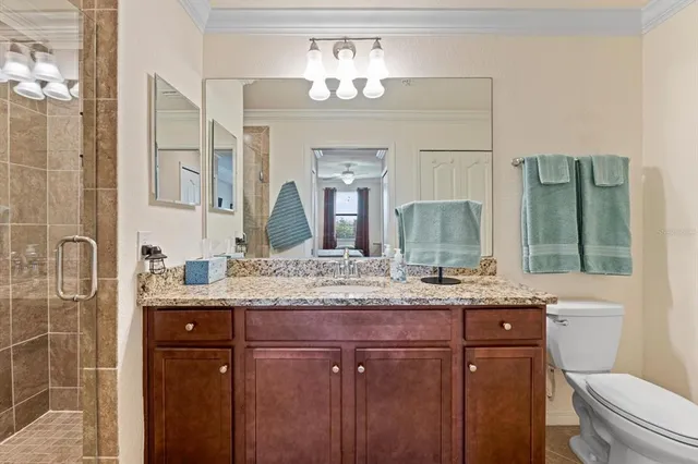 a bathroom with a granite countertop sink a toilet and shower