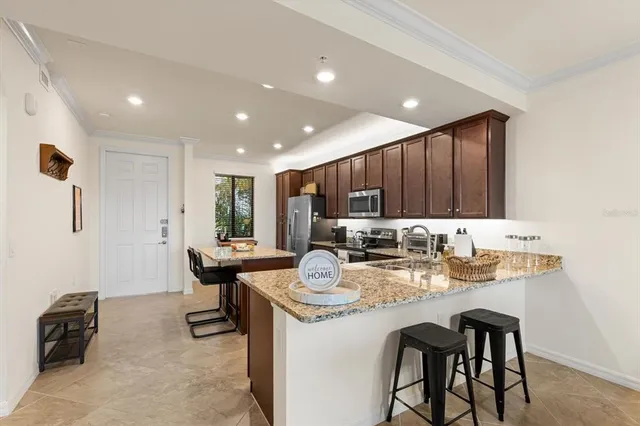 a workspace with stainless steel appliances kitchen island granite countertop furniture and a refrigerator