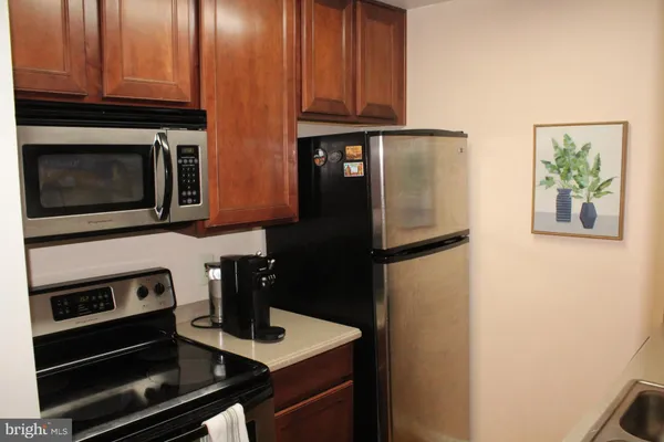 a kitchen with stainless steel appliances granite countertop a refrigerator and a stove top oven