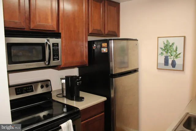 a kitchen with stainless steel appliances granite countertop a refrigerator and a stove top oven