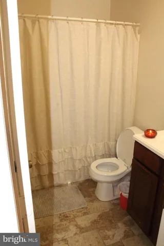 a bathroom with a toilet and a shower curtain