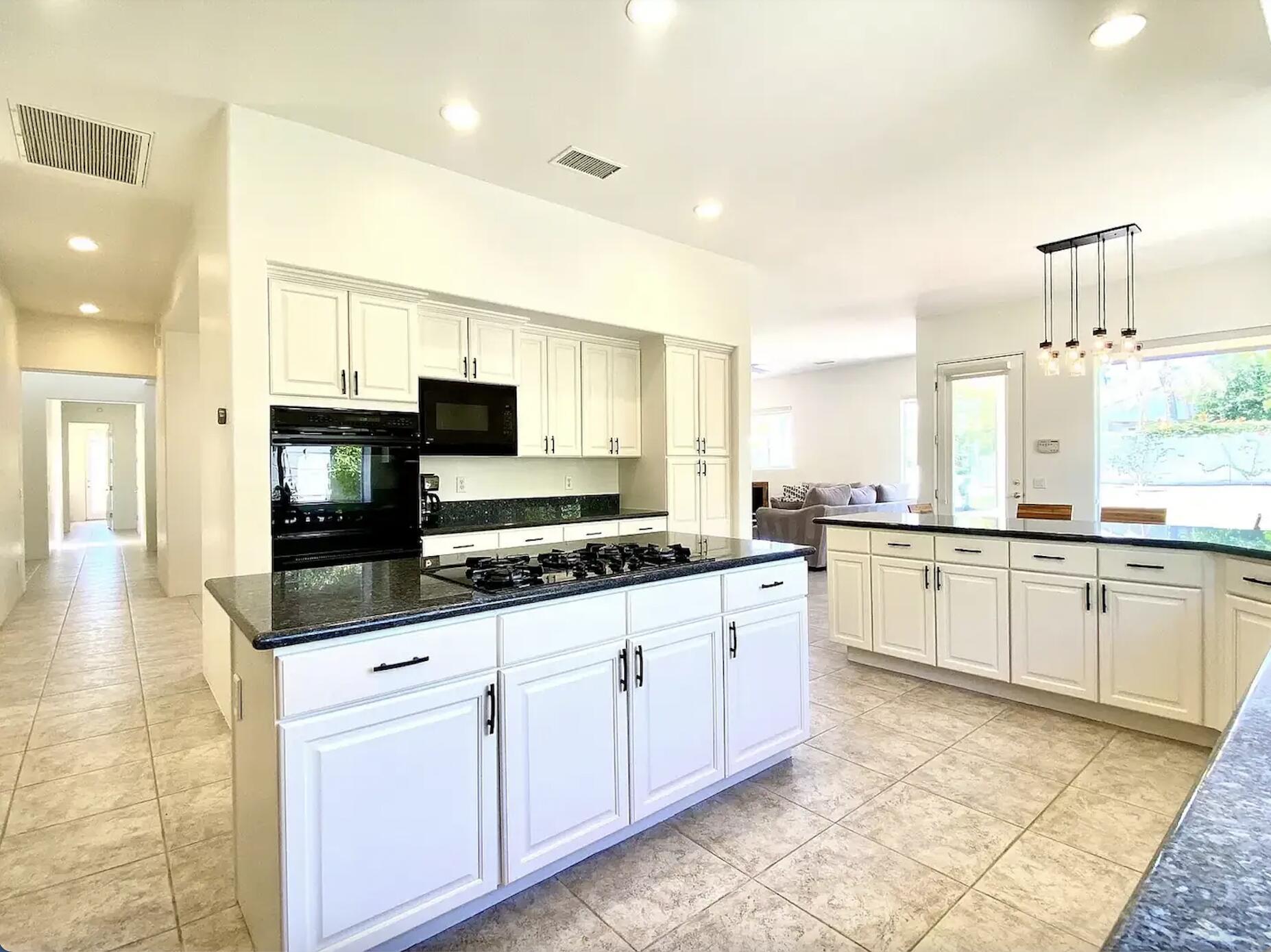 5 Victoria Falls Drive Rancho Mirage, CA 92270 - Photo 15 of 26 a large kitchen with granite countertop a large counter top space appliances and cabinets