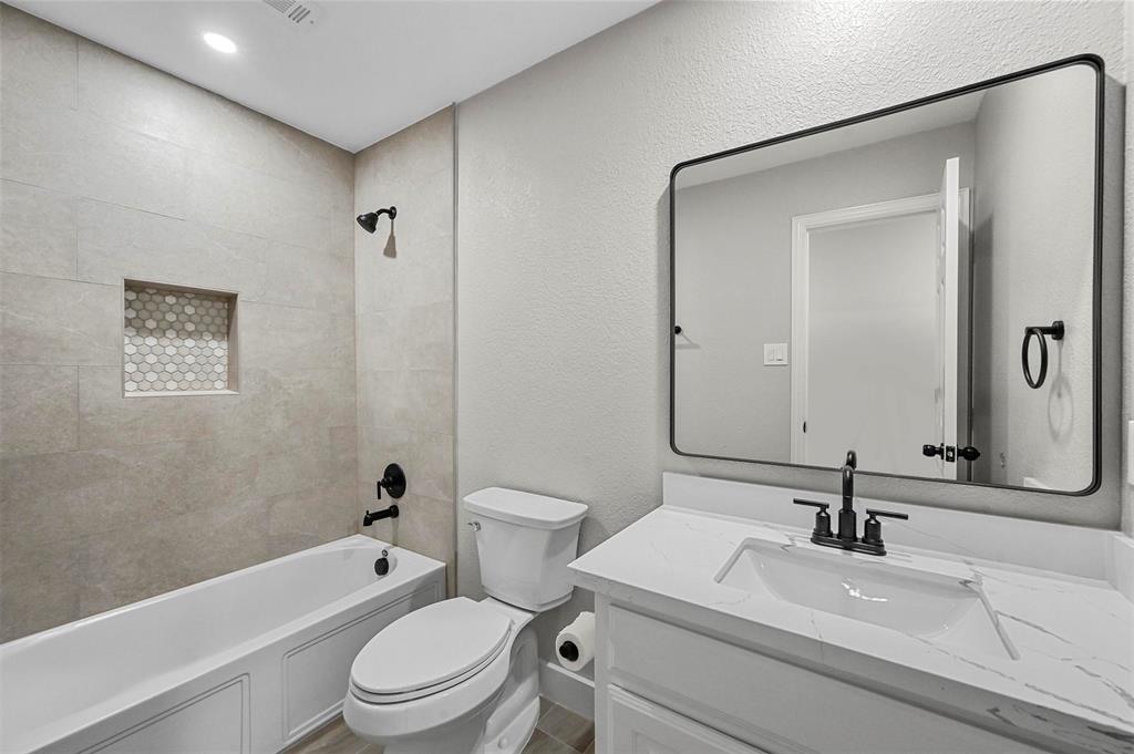 2667 Lake Ridge Drive Little Elm, TX 75068 - Photo 12 of 17 a bathroom with a sink a toilet and a mirror