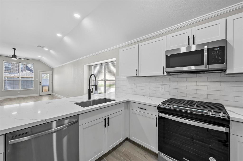 2667 Lake Ridge Drive Little Elm, TX 75068 - Photo 4 of 17 a kitchen with stainless steel appliances a sink stove and microwave
