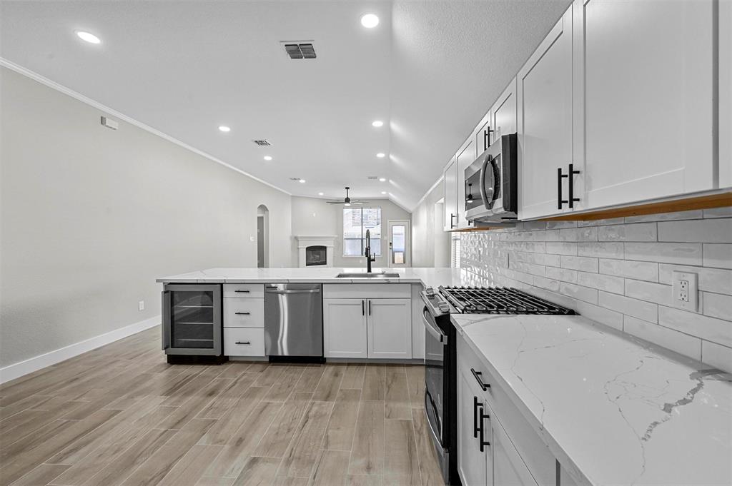 2667 Lake Ridge Drive Little Elm, TX 75068 - Photo 5 of 17 a kitchen with a sink a stove and cabinets