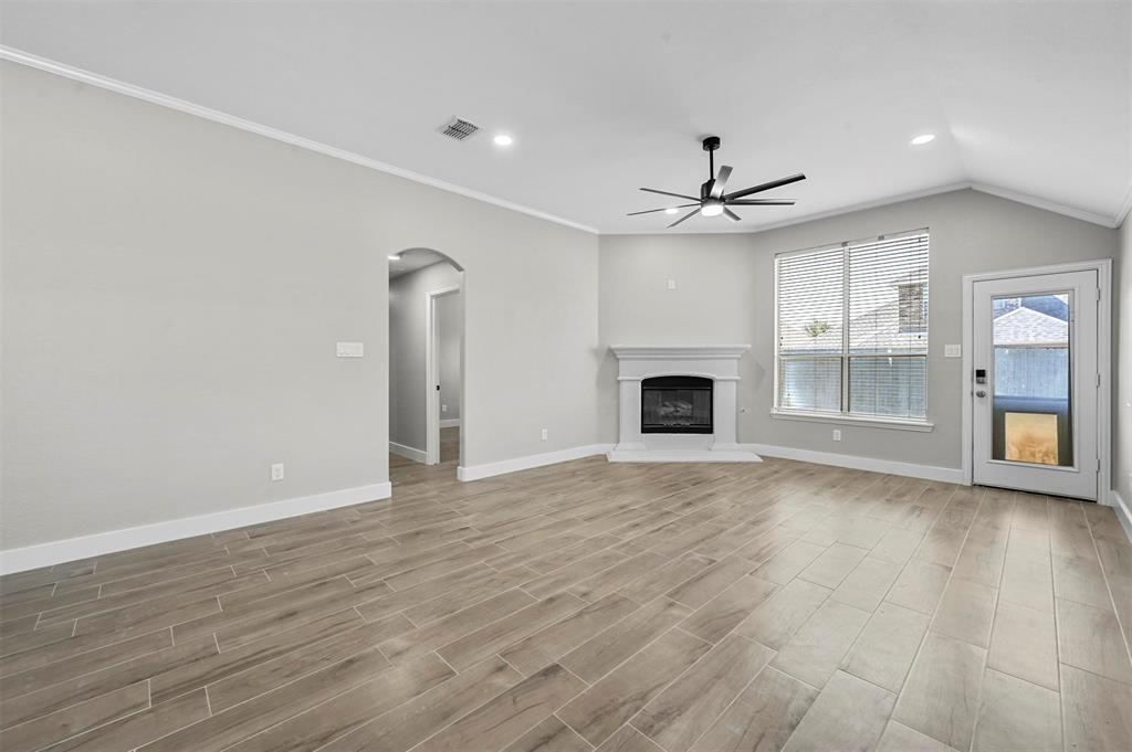 2667 Lake Ridge Drive Little Elm, TX 75068 - Photo 8 of 17 an empty room with a fireplace and chandelier fan