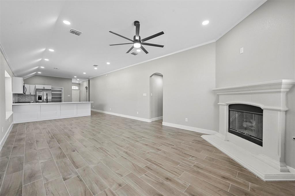 2667 Lake Ridge Drive Little Elm, TX 75068 - Photo 9 of 17 a view of a livingroom with a fireplace a ceiling fan and kitchen space