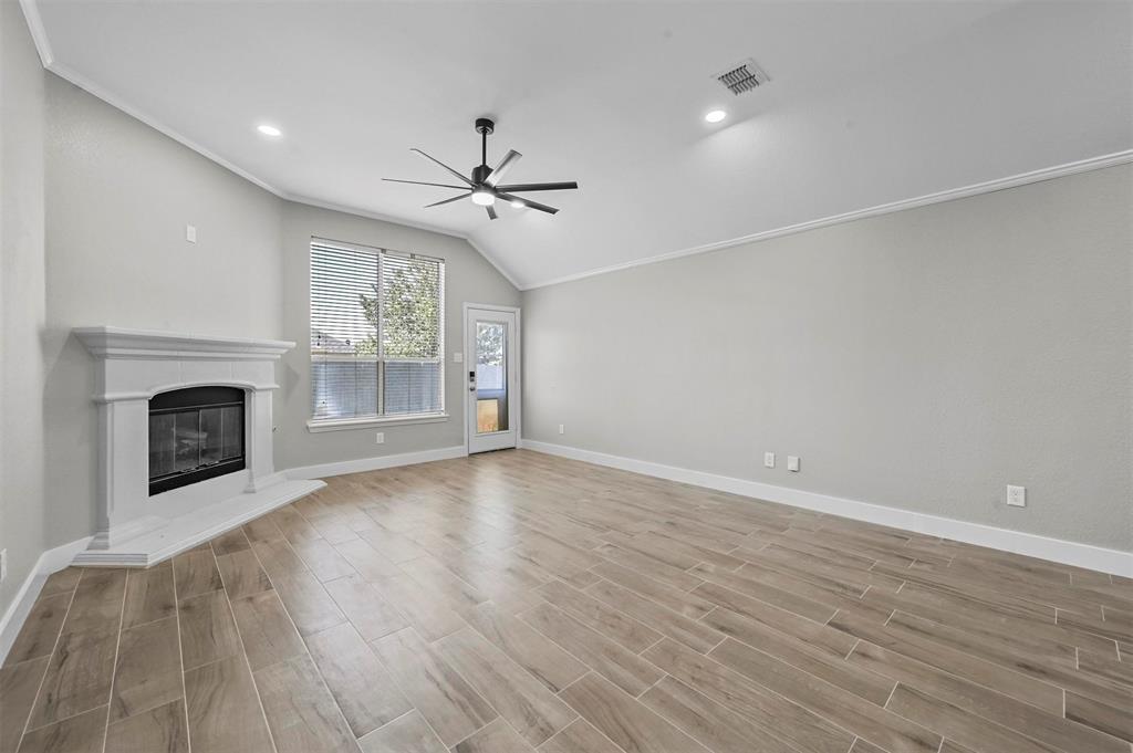 2667 Lake Ridge Drive Little Elm, TX 75068 - Photo 10 of 17 a view of empty room with wooden floor and fireplace