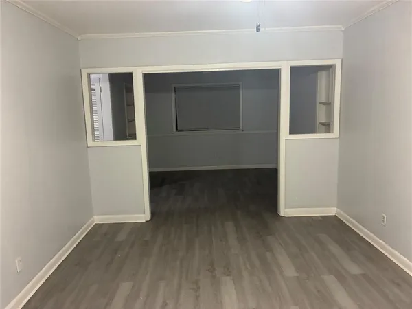 an empty room with wooden floor and closet