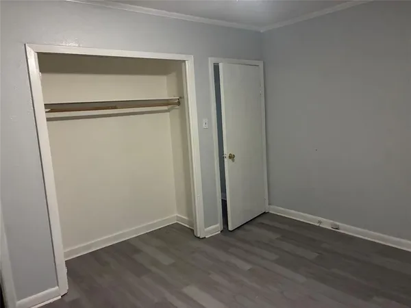 an empty room with wooden floor and a window
