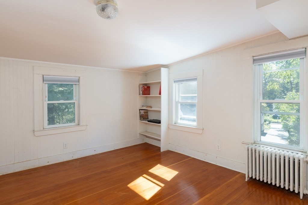9 Belfry Terrace Lexington, MA 02421 - Photo 21 of 23 a view of an empty room with a window and wooden floor