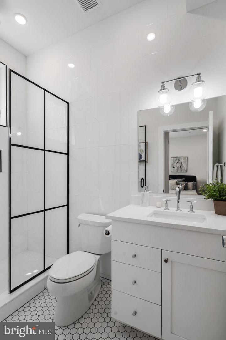 1910 Brown Street Philadelphia, PA 19130 - Photo 15 of 31 a bathroom with a toilet a sink a mirror a shower a vanity and window