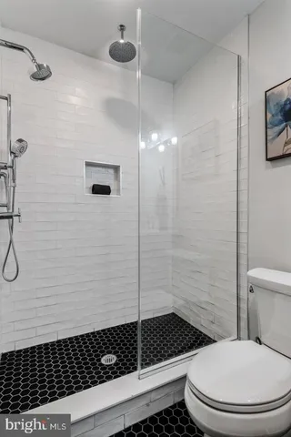 a bathroom with a toilet and a shower